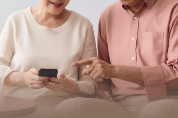 Elderly couple looking at a continuous glucose monitor device