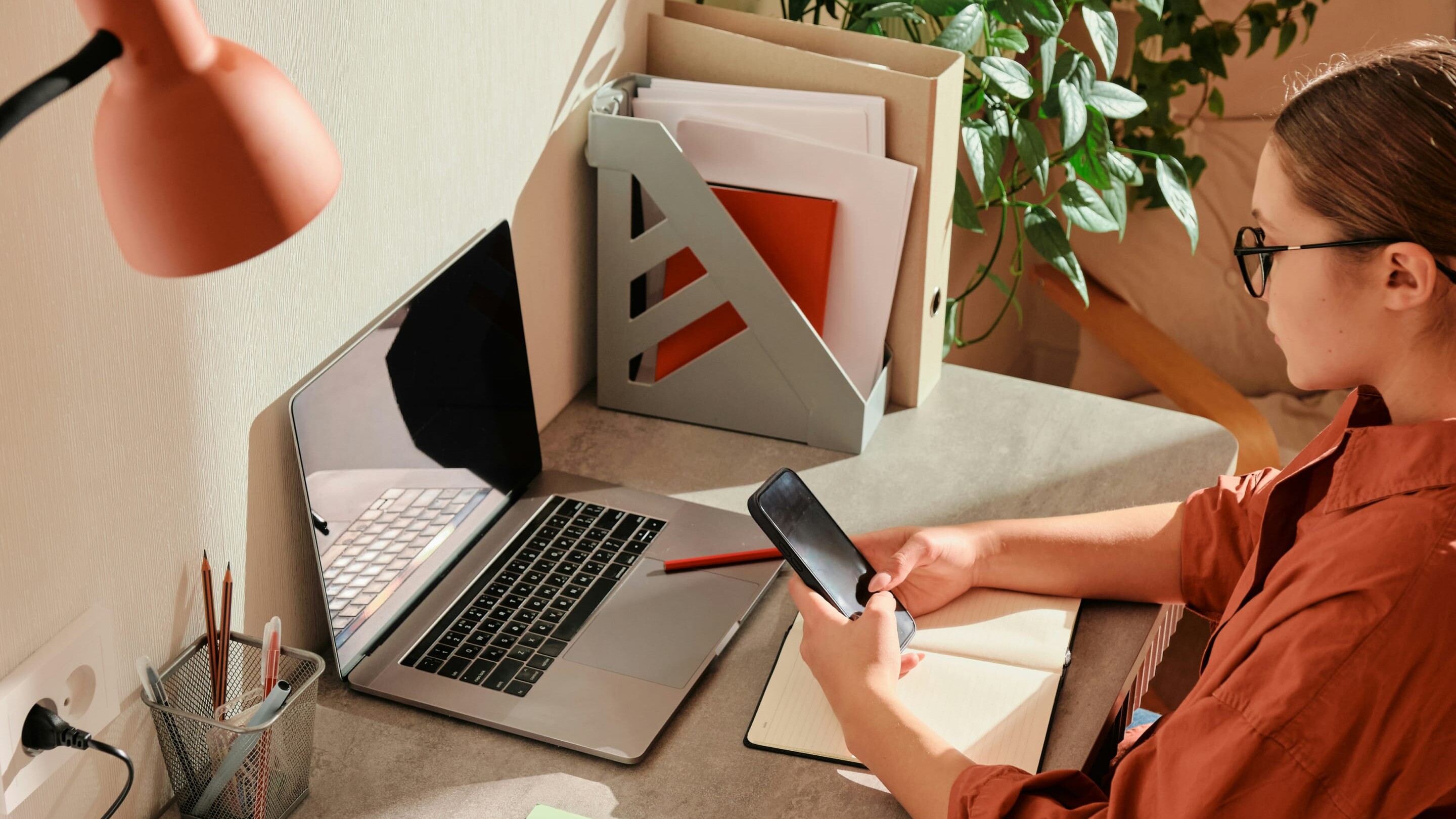 A business owner sits at a desk working on her laptop.